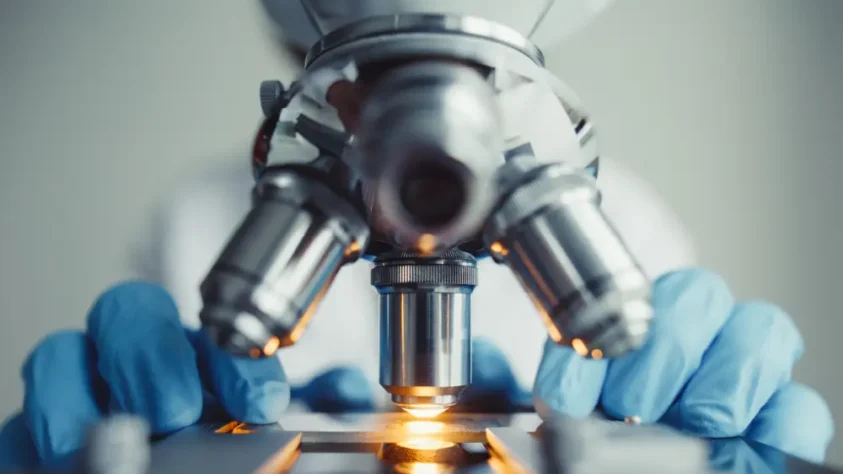 close up view of a scientist using a microscope