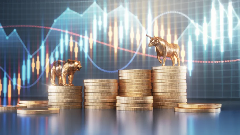 Bull and Bear standing on gold coins, with financial charts in the background