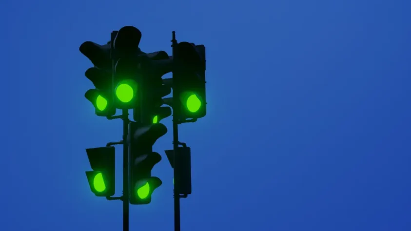 six traffic lights all showing green, on a dark blue sky background