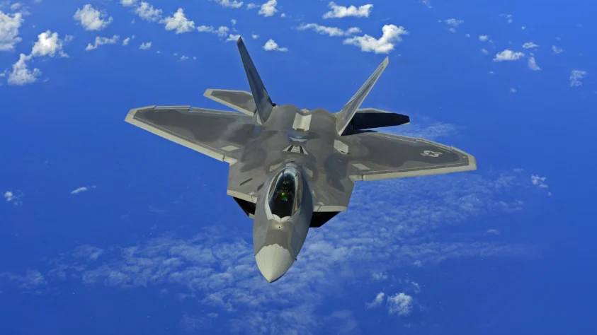 A fighter jet flying through a blue sky